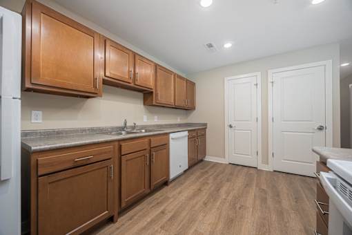 A kitchen with wooden cabinets and a white fridge.
