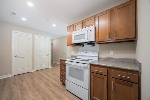 A kitchen with a white stove and wooden cabinets.