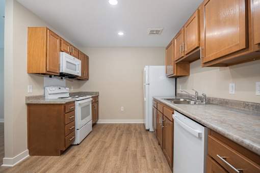 A kitchen with wooden cabinets and a white refrigerator.