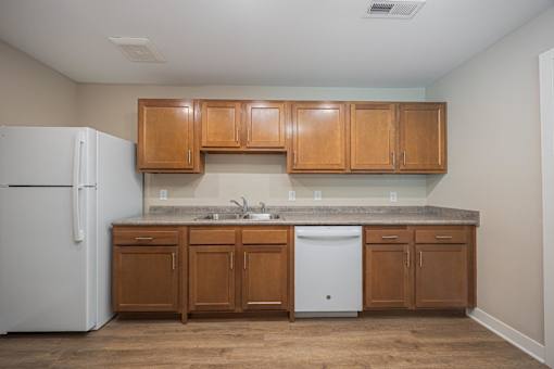 A kitchen with wooden cabinets and a white fridge.