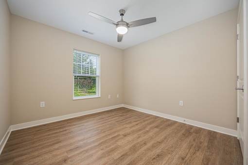 Empty room with a ceiling fan and a window.