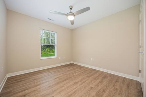 Empty room with a ceiling fan and a window.