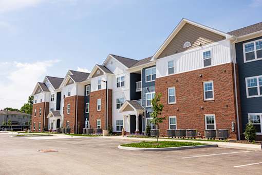 A row of townhouses with a parking lot in front.