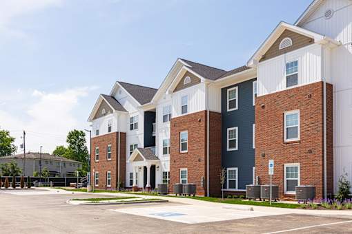 A row of townhouses with a parking lot in front.