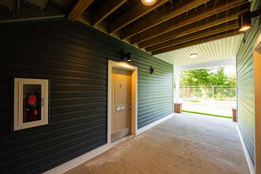 A room with a wooden ceiling and a door with a number 22 on it.