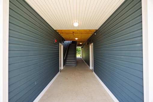 A long hallway with a staircase in the middle.