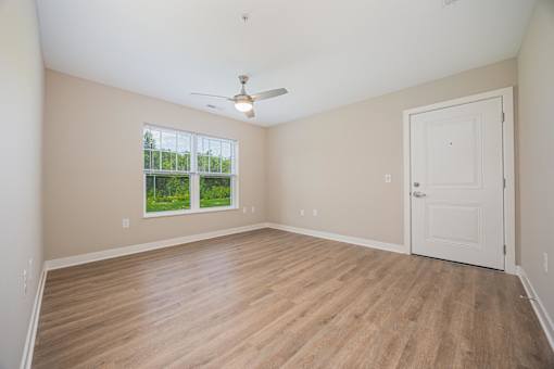 A room with a white door and a ceiling fan.