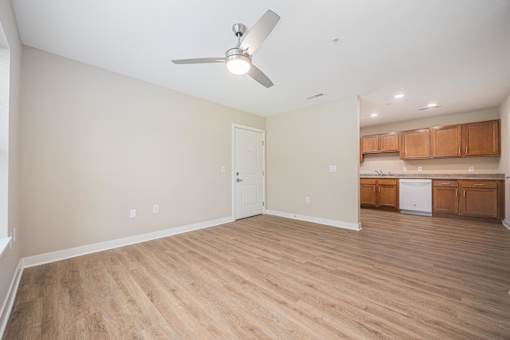 A room with a ceiling fan and wooden flooring.