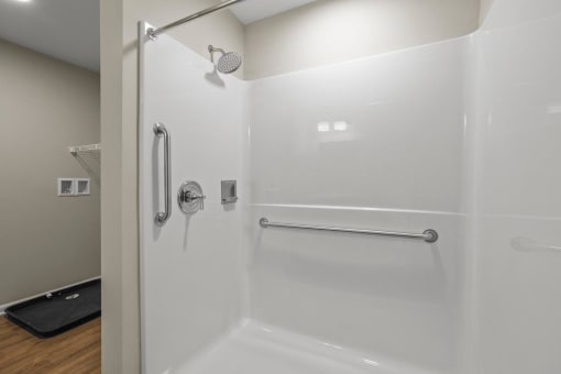 a white bathroom with a shower and a towel rack