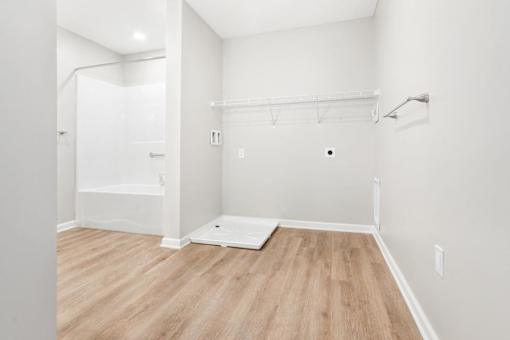 a white bathroom with a shower and a wooden floor