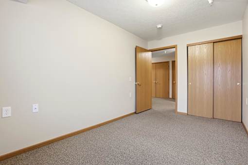 A hallway with two doors and a carpeted floor.