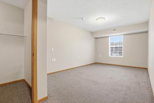 Empty room with carpeted floor and white walls.