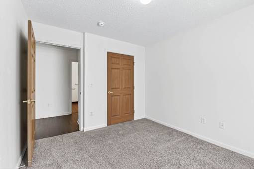 A room with a brown door and a white wall.