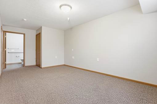 A room with a carpeted floor and a doorway leading to another room.