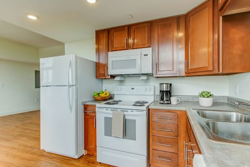 A kitchen with wooden cabinets and white appliances.