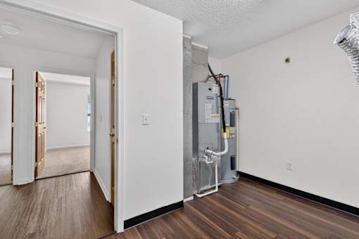 A room with a wood floor and a wall-mounted air conditioning unit.
