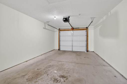 A garage with a white door and a white wall.