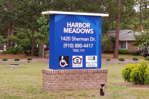 a sign in front of a house that says harbor meadows 144 sherman dr