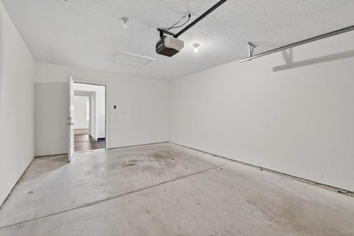 A large empty room with a concrete floor and white walls.