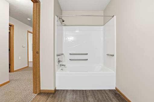 A white bathroom with a walk-in shower and a towel bar.