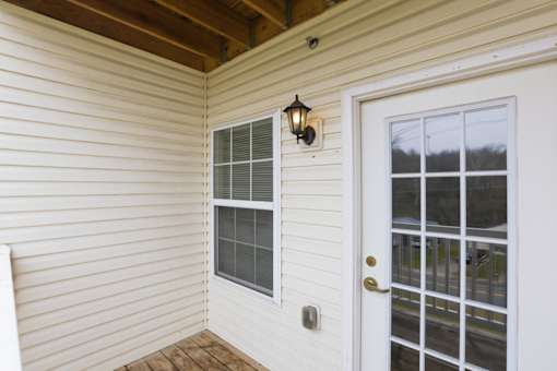 A white door with a window and a light on the wall.