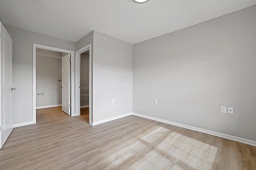 the living room and dining room of a house with white walls and wood floors