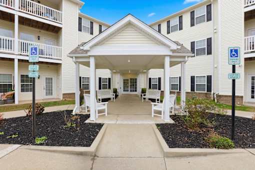 A building with a covered walkway and parking spaces for disabled individuals.