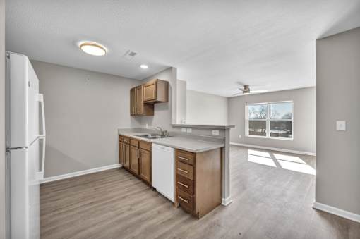 A kitchen with a white refrigerator and wooden cabinets.