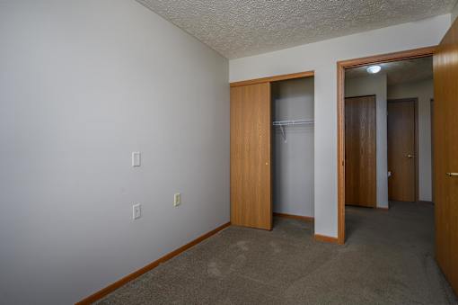 A room with a white wall and a brown door.