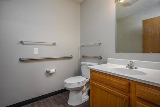A white toilet sits next to a white sink in a bathroom.