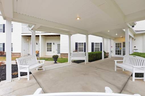 A white covered patio with benches and a table.