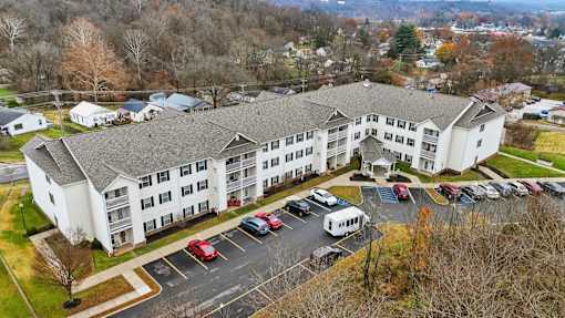 A large white building with a parking lot in front of it.
