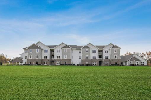 the apartments are located on a large green field