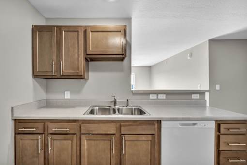 A kitchen with wooden cabinets and a white dishwasher.