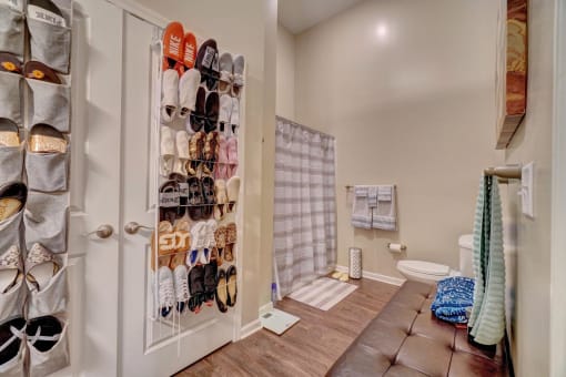 a closet filled with shoes next to a toilet