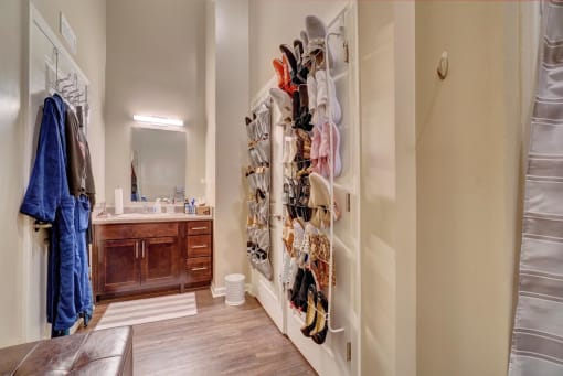 a walk in closet in a bedroom with a sink and a mirror
