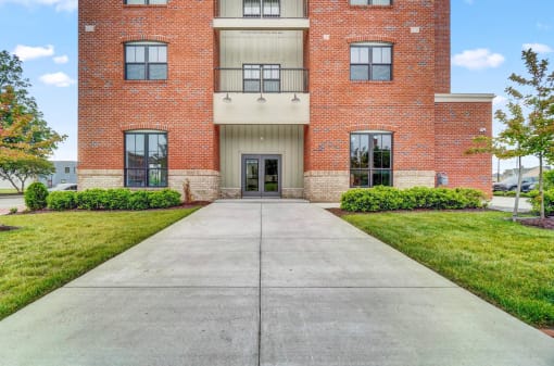 a large brick building with a concrete walkway in front of it
