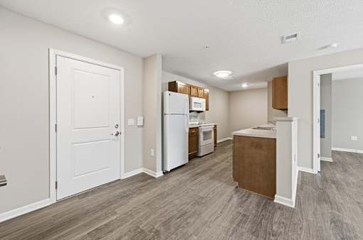 A kitchen with a white door, a white fridge, a white oven, and a white microwave.
