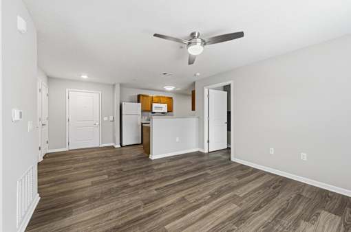 A room with a ceiling fan and wooden flooring.