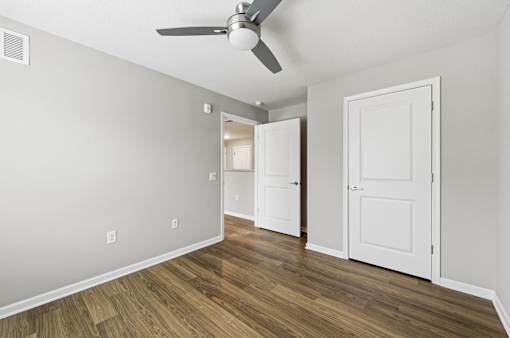 A room with a ceiling fan and two doors.