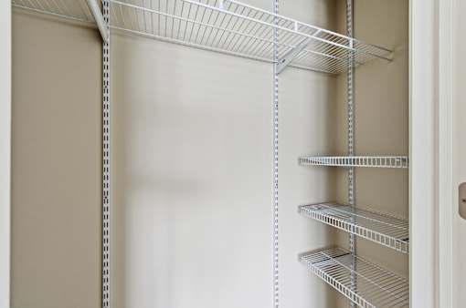 Empty shelves in a white pantry.