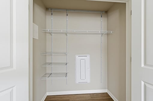 A white pantry with shelves and a light switch.
