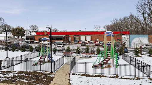 A playground with a green slide and red and blue slide.