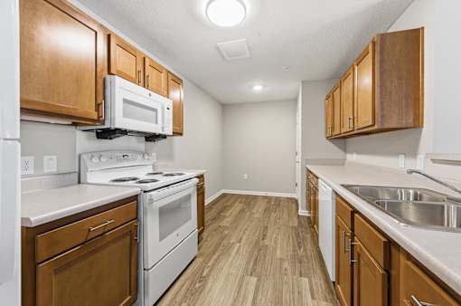 A kitchen with wooden cabinets and white appliances.
