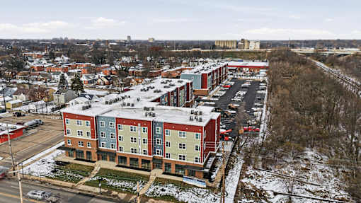 A large apartment complex with a parking lot in front.