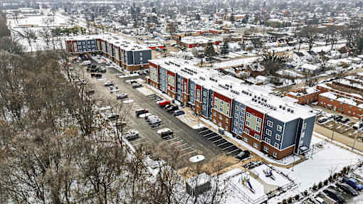 A large building complex with a parking lot in front.