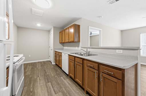 A kitchen with wooden cabinets and a white stove top oven.