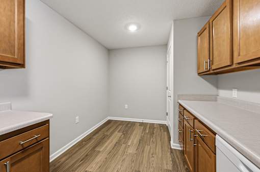 A kitchen with wooden cabinets and a white countertop.