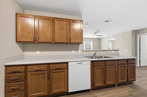 A kitchen with wooden cabinets and a white dishwasher.
