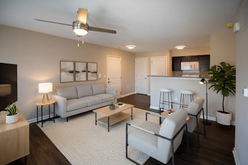 A living room with a grey sofa, a coffee table, and a ceiling fan.